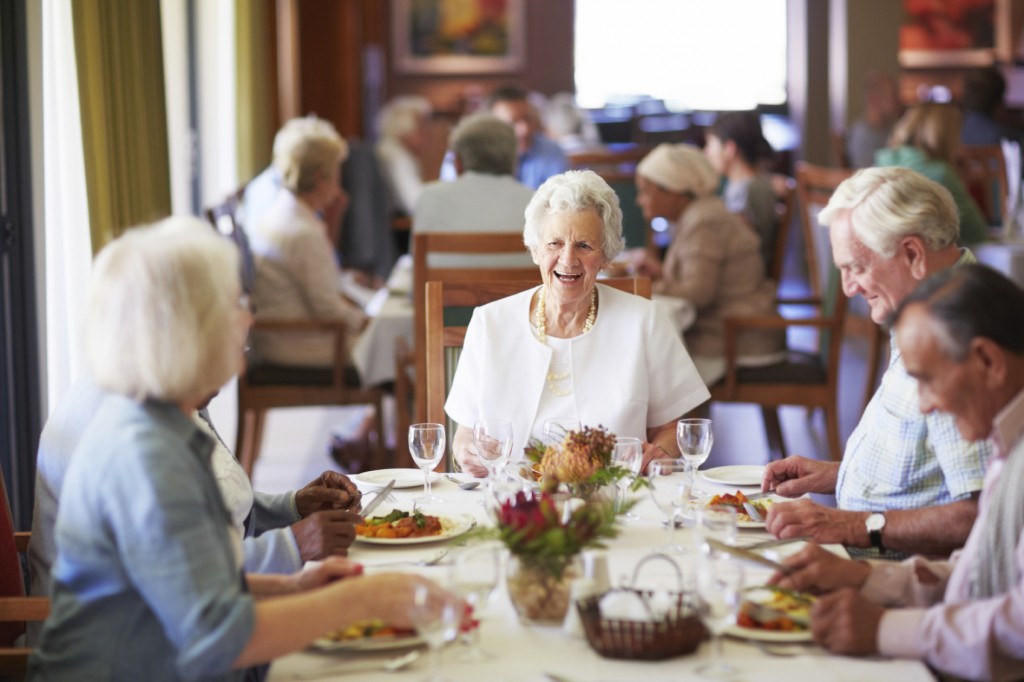 Group of elderly people having lunch together at their old age home