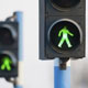 Green lights for pedestrians on two semaphores in traffic.